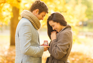 Canvas Print - man proposing to a woman in the autumn park