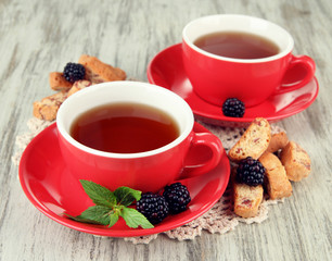 Wall Mural - Cups of tea with cookies and blackberry on table close-up