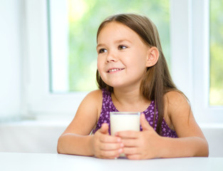 Wall Mural - Cute little girl with a glass of milk