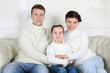 © Pavel Losevsky - Father and mother hugs little daughter and sit on sofa