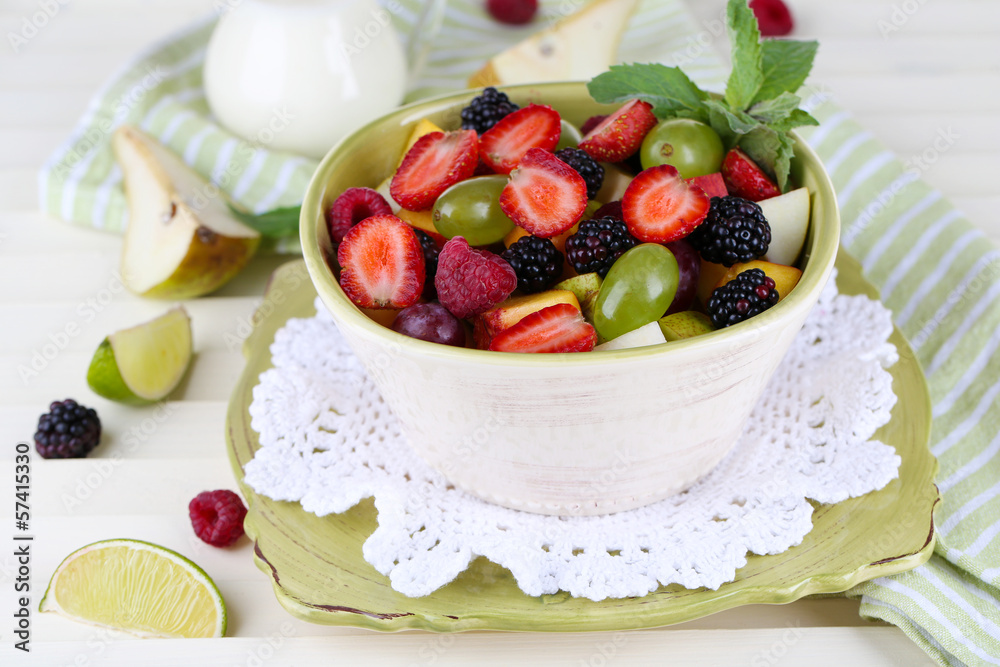 Fruit salad in plates on wooden table near napkin