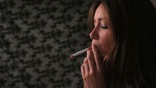 Attractive Brunette Smoking Cigarette In Dark Room