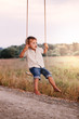 © diosmirnov - Happy young boy playing on swing in a park