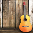 © Digital Storm - Acoustic wooden guitar leaning on a wooden fence.