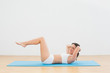 © lightwavemedia - Sporty woman doing sits up at fitness studio