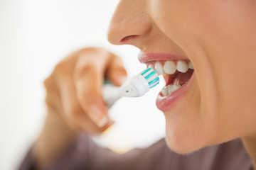 Poster - Closeup on happy young woman brushing teeth