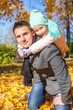 © travnikovstudio - Adorable little girl with happy father having fun in autumn park