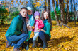 © travnikovstudio - Young family with litlle girls in autumn park on sunny day