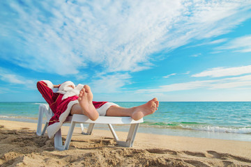 Sticker - sunbathing Santa Claus relaxing in bedstone on tropical sandy be