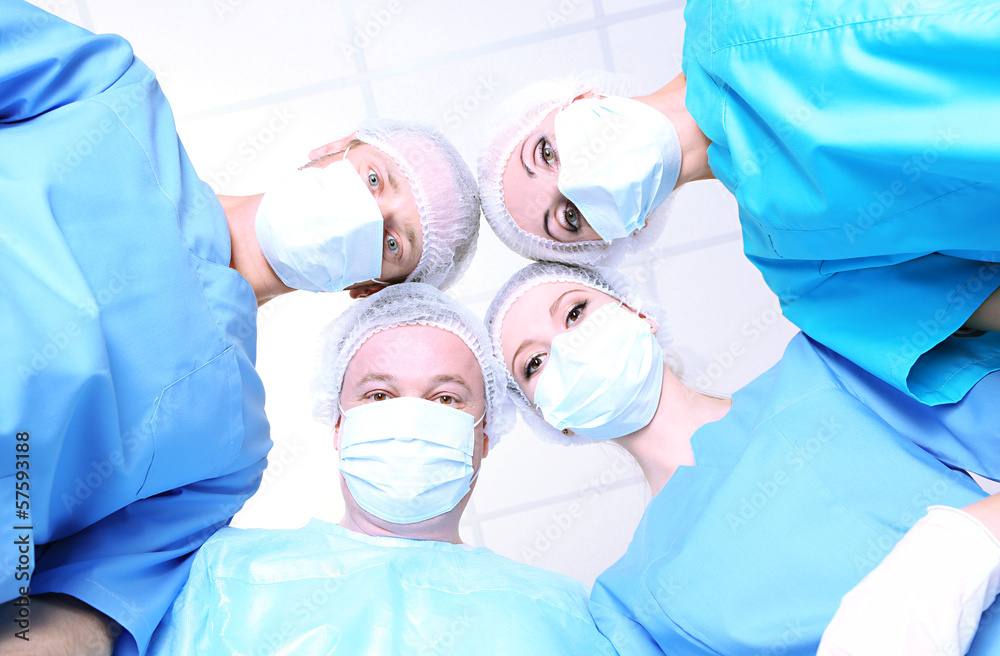 View from below of surgeons in protective work wear during