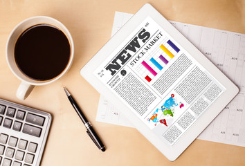 Wall Mural - tablet pc shows news on screen with a cup of coffee on a desk