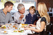 © Robert Kneschke - Grandfather feeding grandson in restaurant