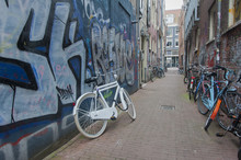 Bicycle Leaned Against Griffiti Covered Wall In Amsterdam