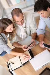 Wall Mural - Business people using smartphone in meeting