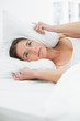 © lightwavemedia - Woman covering ears with pillow in bed