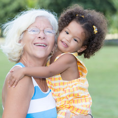 Grandma carrying her hispanic granddaughter