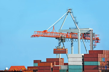 Container stack and ship under crane bridge