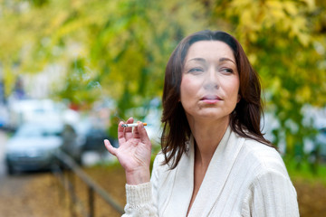 attractive mature woman smoking outside