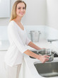 © lightwavemedia - Happy gorgeous woman filling pan with water