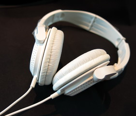 Modern white headphone isolated on black background