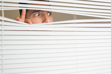 Scared Male Eyes Spying Through Roller Blind
