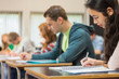 © WavebreakmediaMicro - Group of students writing notes in classroom