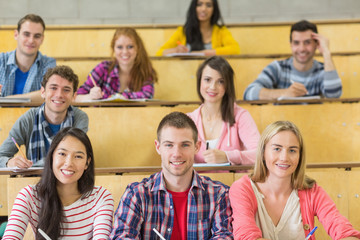 Poster - Smiling students sitting at the lecture hall
