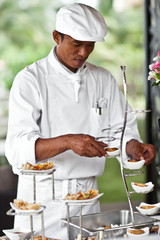 Asian chef laying a table with luxury food and drinks on wedding