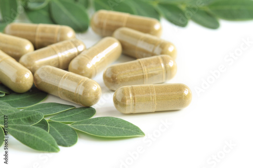 Fotografia Moringa oleifera capsule with green fresh leaves on white backgr