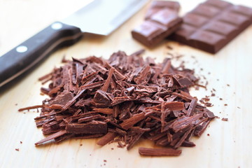 Sticker - Chopped bar of dark chocolate on wooden background