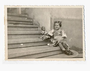 Wall Mural - Little girl with doll on the stairs - circa 1950