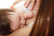 © Khorzhevska - young mother breast feeding her infant over white