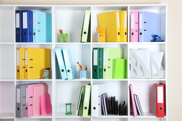 White office shelves with folders and different stationery,