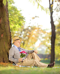 Sticker - Gentleman with flowers sitting on a grass and checking the time