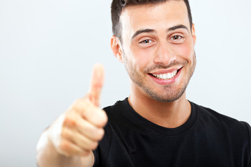 Smiling young man with thumbs up