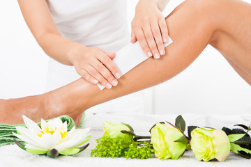 Beautician Waxing A Woman's Leg