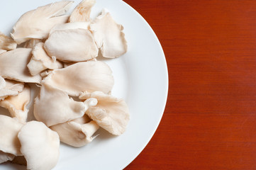 raw mushrooms in a plate on wooden table