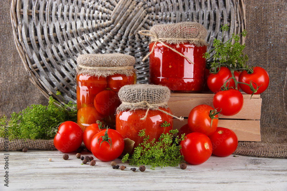 Tasty canned and fresh tomatoes on wooden table
