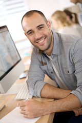 Aufkleber - Cheerful guy sitting in front of desktop computer