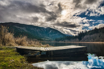 Fototapete - Dock on Lake with Dramatic Clouds