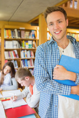 Poster - Male student with others in background at library