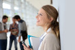 © goodluz - Young woman in school campus using smartphone