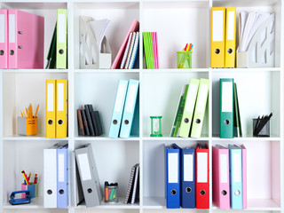 White office shelves with folders and different stationery,