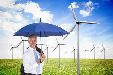 Poster - Composite image of businessman holding umbrella smiling at camer