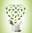 Herbs falling into mortar in shape of heart on green background