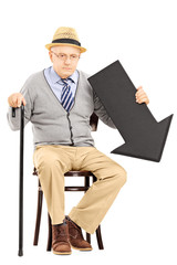 Wall Mural - Sad senior man sitting on bench with black arrow pointing down