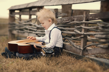 cute little boy with guitar on location