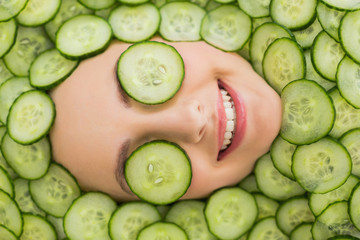 Beautiful woman with facial mask of cucumber slices on face