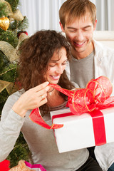 Poster - Happy Couple Opening Christmas Gift. Christmas Family