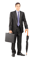 Wall Mural - Businessman in black suit holding an umbrella and briefcase